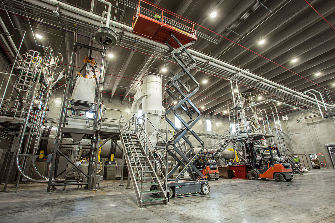 Industrial facility with elevated work platforms and material handling equipment